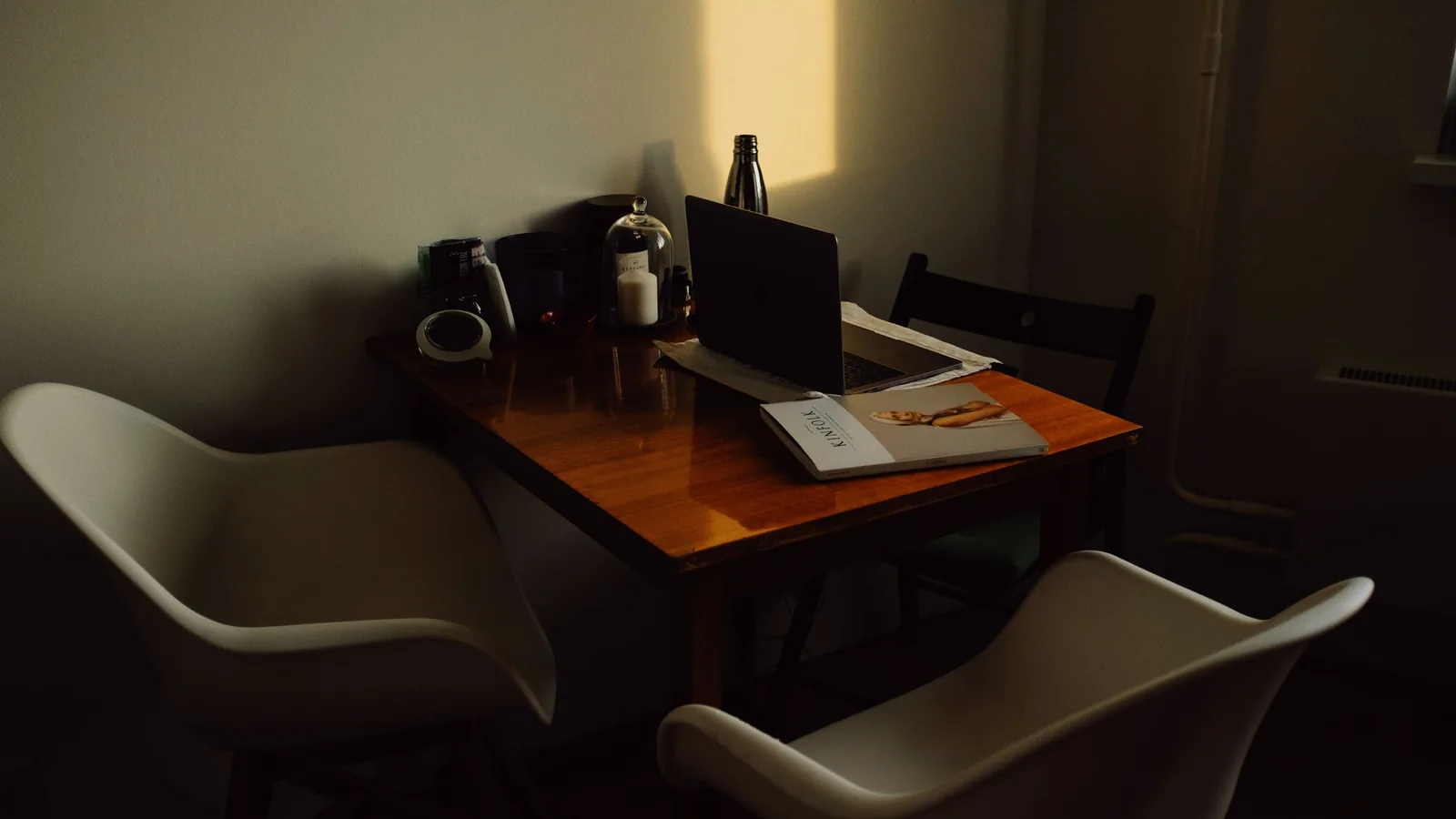 Mesa de reuniones de madera con documentos y luz natural en un despacho de Barcelona
